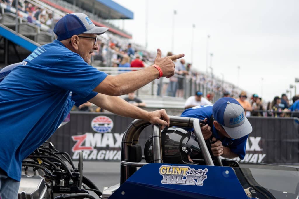 an nhra drag racing crew member shouting during a race